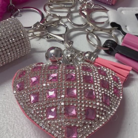 Includes: Pink Heart Wristlet, Bling Heart Charm, Seat Belt Cutter, Chapstick Holder, Bling Hand Sanitizer, Pepper Spray and Pompom.