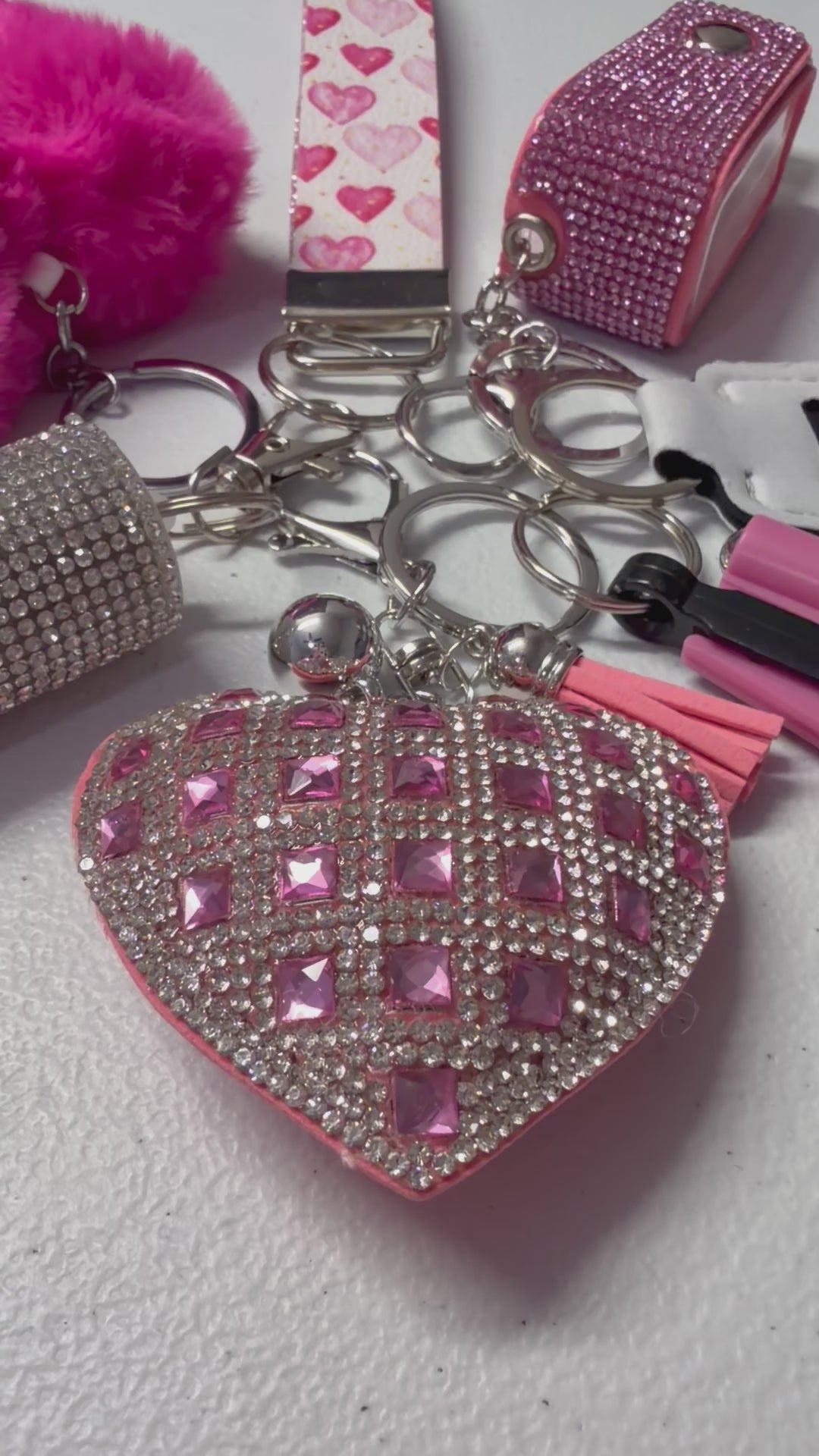 Includes: Pink Heart Wristlet, Bling Heart Charm, Seat Belt Cutter, Chapstick Holder, Bling Hand Sanitizer, Pepper Spray and Pompom.